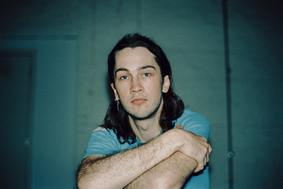 Didirri sits arms crossed, looking directly at the camera